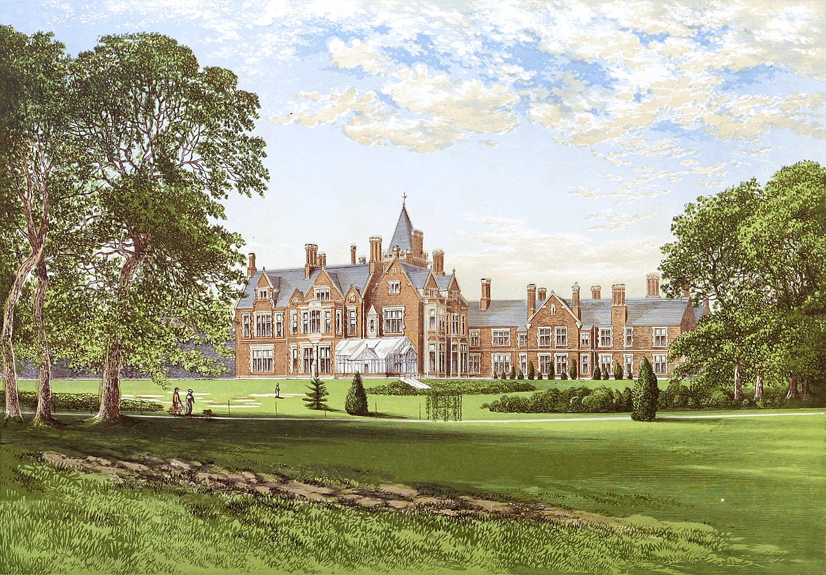 Historic brick mansion with landscaped gardens, framed by trees under a blue sky.
